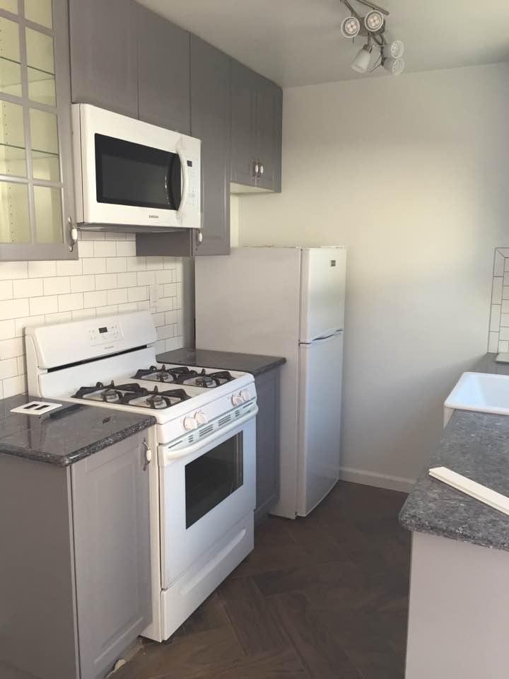 Bright, compact kitchen with white appliances and subway tile backsplash.