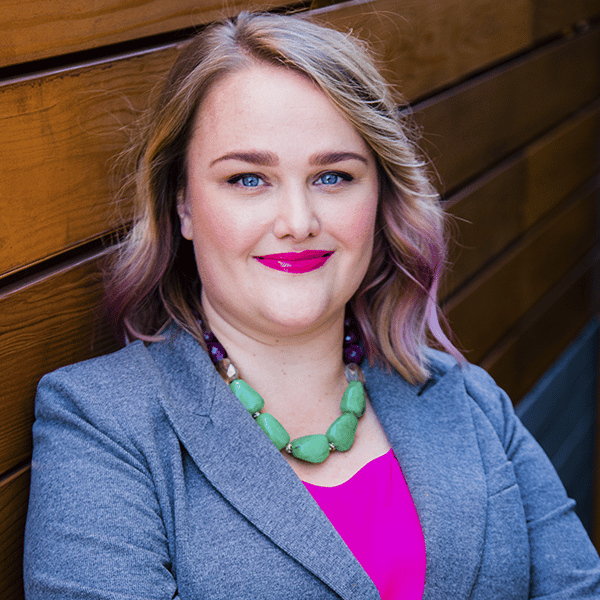 Professional woman with light purple hair and a confident smile.