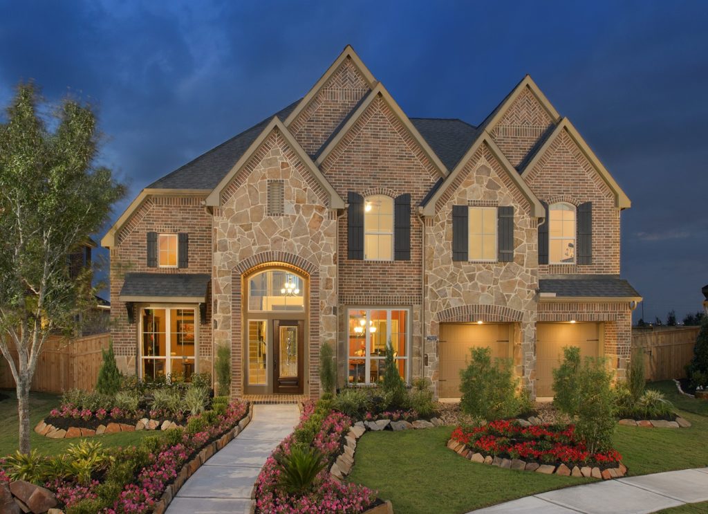 Elegant brick house with warm exterior lighting at dusk.