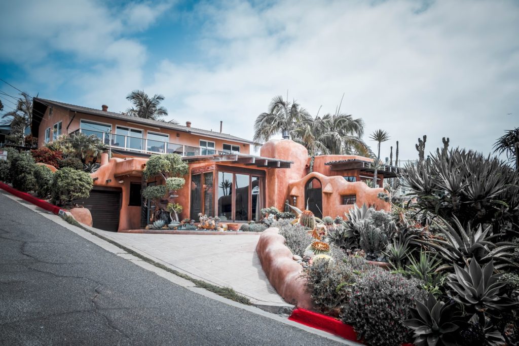 Unique adobe-style home with organic curves and desert landscaping.