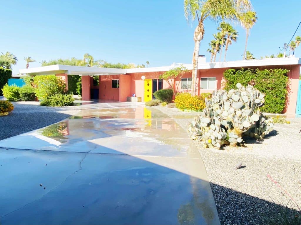 A Palm Springs House that our founder, Rhianna, invested in. It is pink with a yellow door, and has a large front lot for beautiful curb appeal